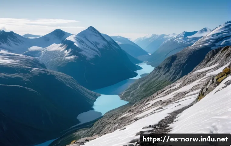 노르웨이 산악 등반 명소 - A panoramic view of a hidden hiking trail in Jotunheimen, Norway, featuring rugged snow-covered moun...